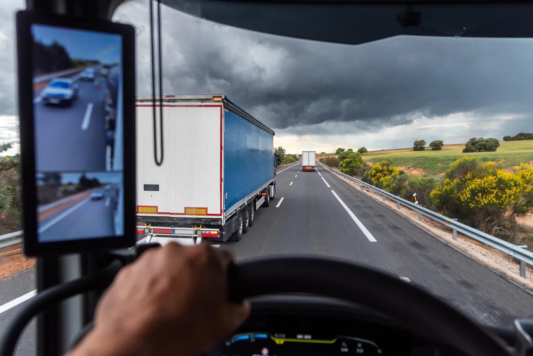 Vy från förarhytten när en lastbil kör om på motorvägen
